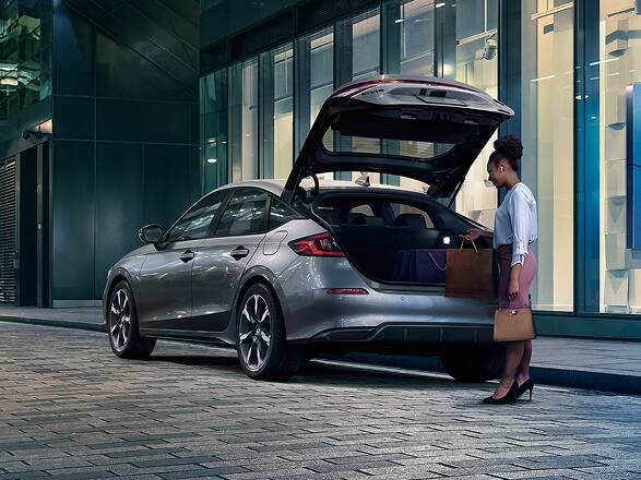 2027 Honda Civic Hatchback Sport Touring Hybrid in Solar Silver Metallic back parked on a city street with the hatch open (Compact Hatchback).